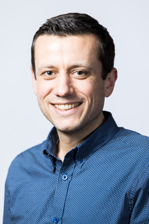 Krueger_0.jpg profile photo of Timm Krueger wearing blue shirt and smiling