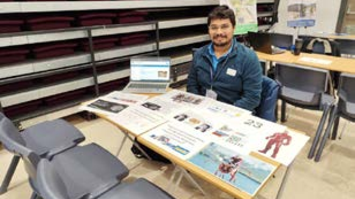 CEF Santhosh Sivasubramani sitting at a desk in Portobello High School providing STEM outreach engagement opportunities
