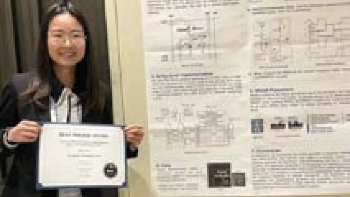 Yihan Pan holding the award for Best Paper at MEMRISYS 2024, standing in front of her award winning scientific poster