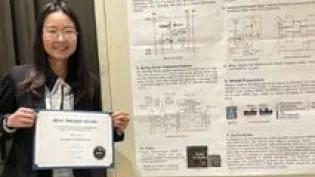 Yihan Pan holding the award for Best Paper at MEMRISYS 2024, standing in front of her award winning scientific poster