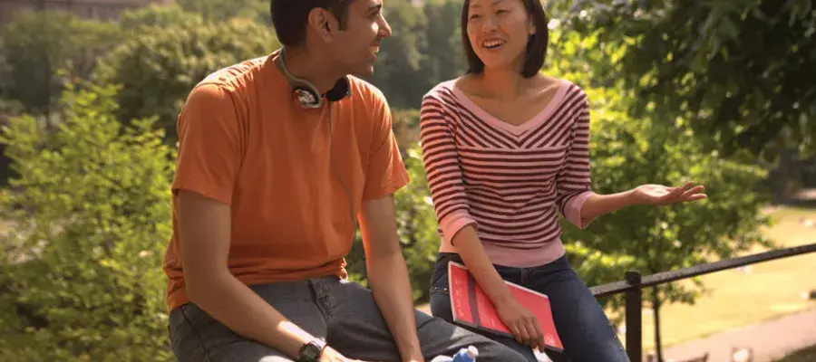 Students talking and laughing while sitting outdoors