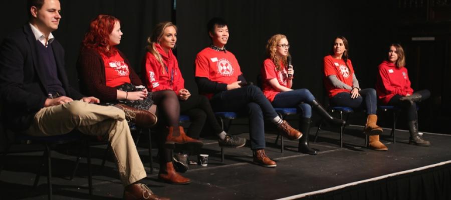 Postgraduate Open Day Q&A panel sitting on stage in dark lecture theatre