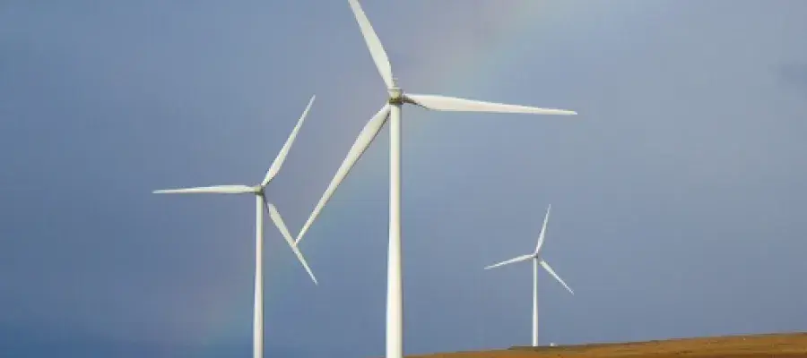 Wind turbine array in green fields with blue sky
