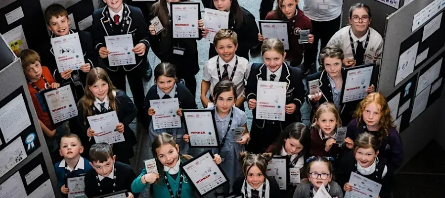 group of primary school children holding primary engineer awards and looking up to camera