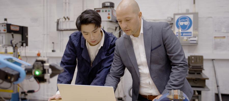 Engineering Supervisor and Postgraduate student working at a laptop in a laboratory