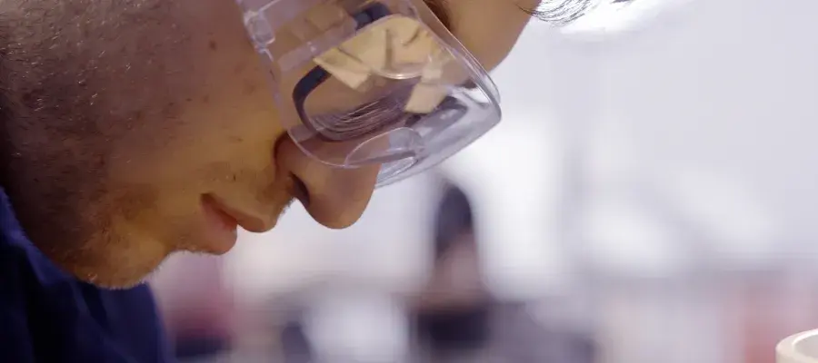 close up profile of Mechanical engineering student working in a laboratory wearing safety goggles