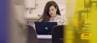 Postgraduate Research engineerint student working at a laptop in the Eng Inn