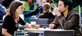 postgraduate taught masters students drinking coffee in sunshine outdoors in edinburgh