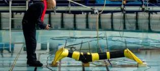 engineering researcher above the pool in the Flowave ocean research facillity