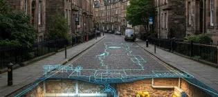 A historic edinburgh street with tenements and cobbles with a digital overlay of what is under the ground