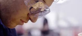 close up profile of Mechanical engineering student working in a laboratory wearing safety goggles