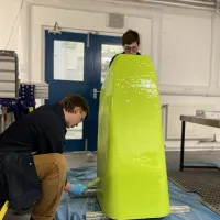 Students working on large yellow block