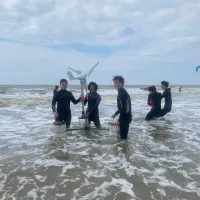 Students in the sea with wind turbine
