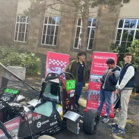 Students beside a racecar