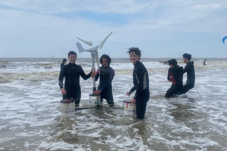 Students in the sea with wind turbine