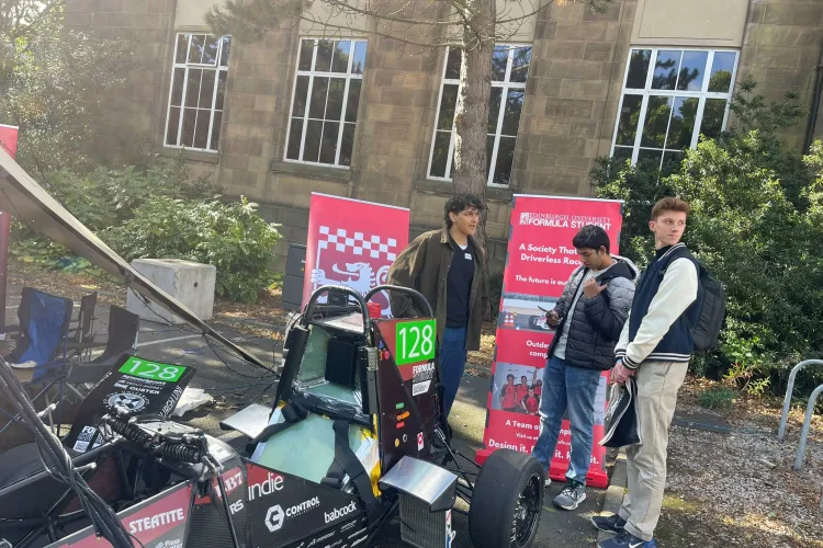 Students beside a racecar