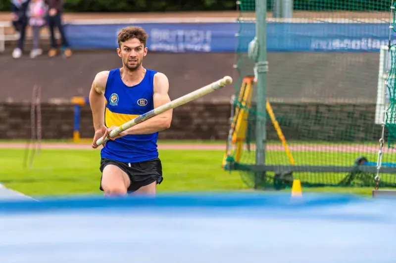 Andrew McFarlane photographed as he runs towards the Pole Vault