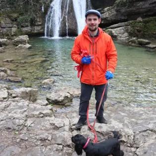 Michael Bryce with dog in front of waterfall