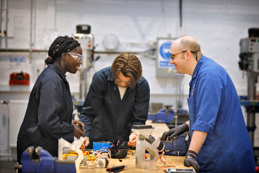 undergraduate engineering students in a workshop with an engineering technician