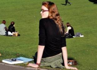 Student sitting on the grass in Edinburgh meadows park