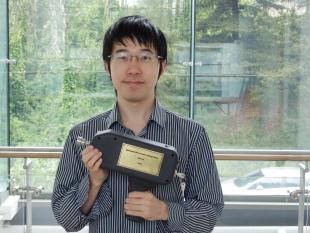 Picture of Di Wu with his prize - A model of the experimental instrument 