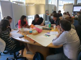 Engineering Students gathered around a table discussing the big issue: How do we collect plastic waste?