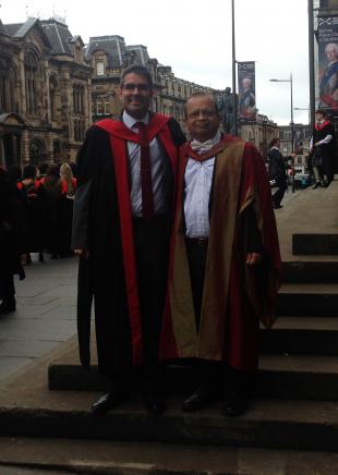 Francesc and Pankaj, in academic gowns, standing on the steps of the Museum of Scotland, Chambers Street, Edinburgh 