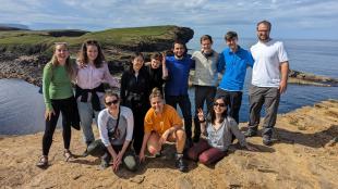 A group of IDCORE students gathered on top of sea cliffs