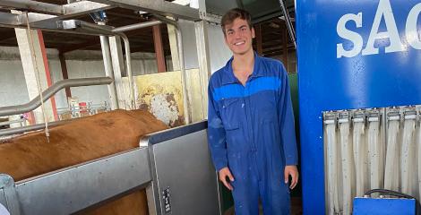 Close up  of Rodrigo wearing blue overalls in a dairy farm